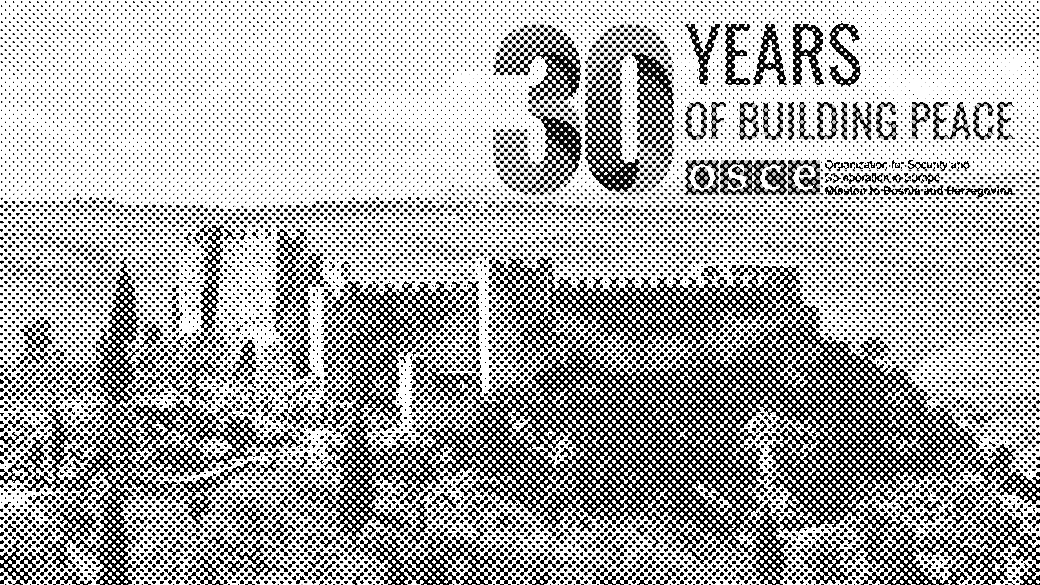 Stari kameni dvorac okružen zelenilom i brdima pod plavim nebom.