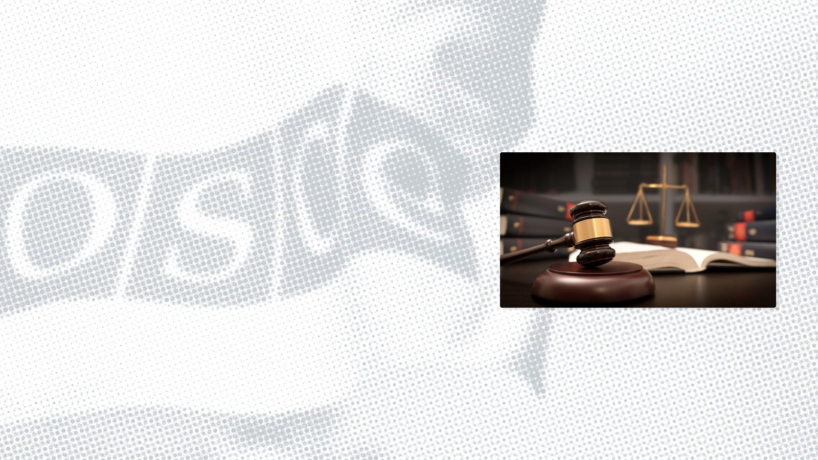 Gavel and scales of justice on a desk with open law book and stacked books in the background.